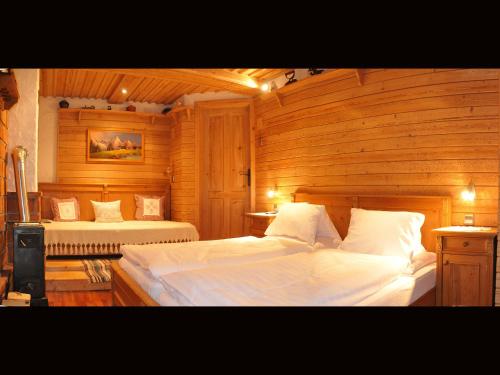 a bedroom with two beds in a wooden room at Romantikappartement Petz**** in Donnersbachwald