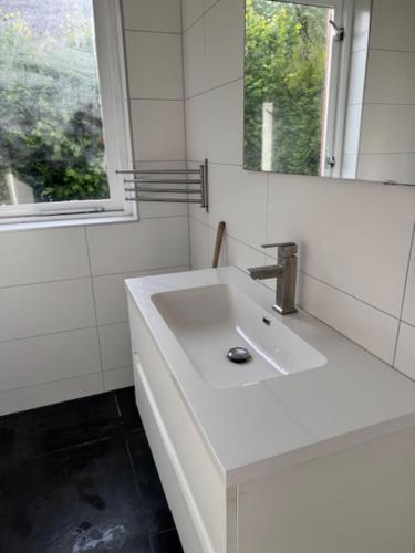 a white bathroom with a sink and a mirror at 5 - Persons Lakeside 41 Bungalow in Ewijk
