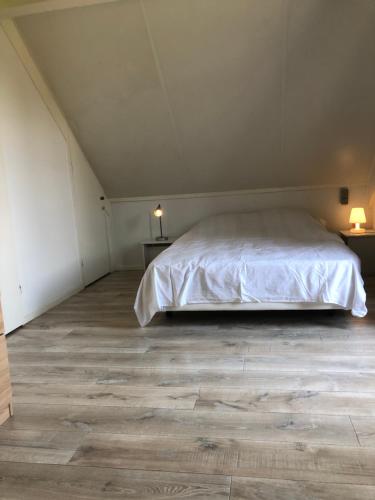 a bedroom with a bed and a wooden floor at 5 - Persons Lakeside 41 Bungalow in Ewijk