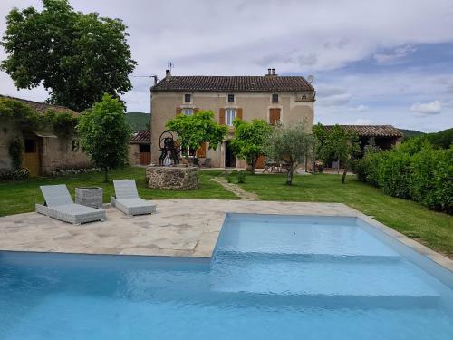 a villa with a swimming pool in front of a house at La Maison d'eglantine in Marnaves