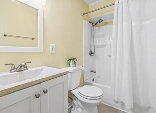 a white bathroom with a toilet and a sink at MarzyMagic Oceanview's in Myrtle Beach