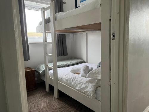 a bedroom with two bunk beds and a window at 22 Longstone Park in Chathill