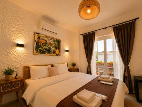 a bedroom with a large white bed and a window at The One Alacatı in Çeşme