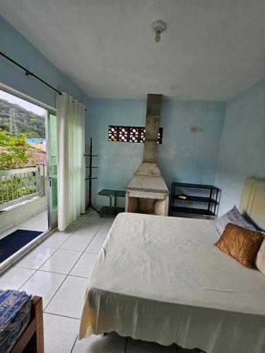 a bedroom with a large bed and a window at Acomodação Recanto do Sameiro in Mongaguá