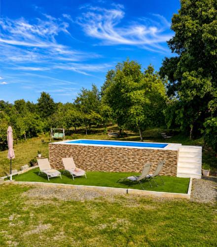 a pool with two chairs and a brick wall at Casa dos Invernos in Paçô