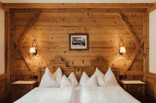 a bedroom with two beds with white pillows at Hotel Colbricon in San Martino di Castrozza