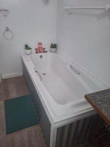 a large white bath tub in a room at Protea in Britannia Bay