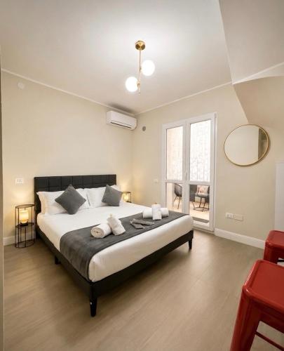a bedroom with a large bed with two towels on it at La Costa Rooms in Flumini di Quartu