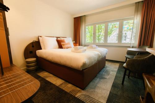 a hotel room with a bed and a window at De Herbergh van Flielant in Oost-Vlieland