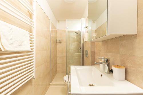 a bathroom with a white sink and a toilet at Olgi Milla Villa in Balatonalmádi