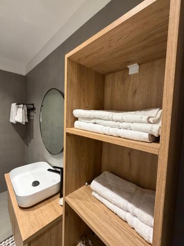 a bathroom with a shelf with towels and a sink at Villa Reger in Lalëz