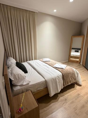 a bedroom with a bed and a table and a mirror at Villa Reger in Lalëz