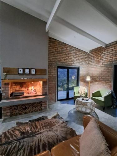 a living room with a fireplace and a couch at Exhale Cottage in Montagu
