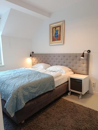 a bedroom with a large bed and a night stand at Villa Antonina Apartamenty z aneksem in Czaplinek