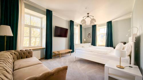 a bedroom with a large bed and a couch at White Palace in Riga
