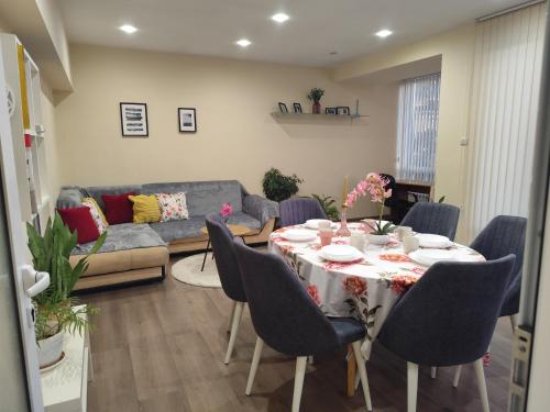 a living room with a table with chairs and a couch at Grand and Prime Central Apartments Varna in Varna City