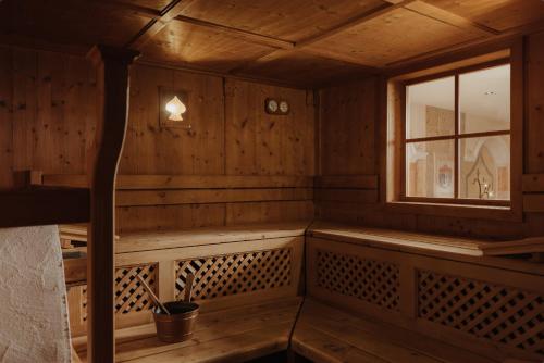 an empty sauna with a window and wooden walls at Hotel Colbricon in San Martino di Castrozza