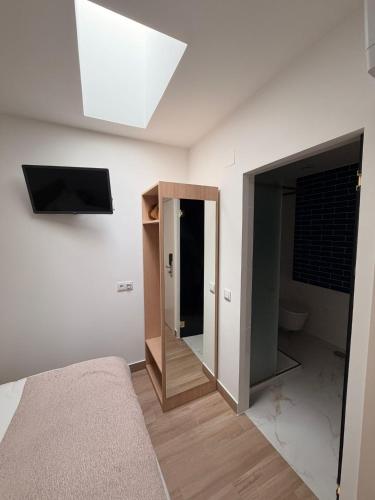 a bedroom with a bed and a mirror and a skylight at B&B Berlenga 4 in Nazaré