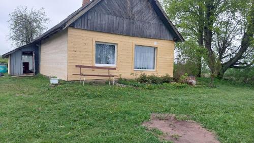 a small house with a bench in front of it at Marija in Krāslava