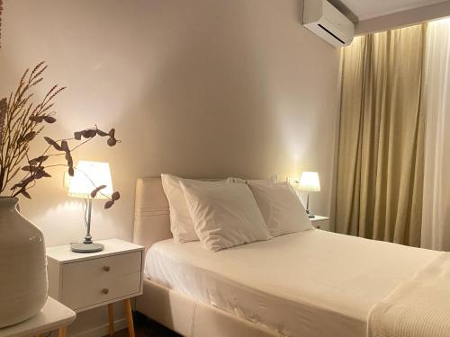 a bedroom with a bed with a lamp and a window at 70 sqm sea view apartment in Parga