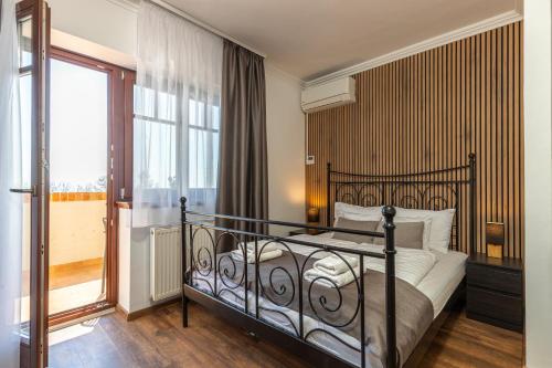 a bedroom with a bed and a large window at Olgi Milla Villa in Balatonalmádi