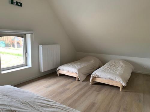 a bedroom with two beds and a window at Vakantiewoning - Perspektiv in Kortemark