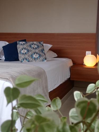 a bedroom with a bed with a pillow and a lamp at Chalé Jenipapo in Serra do Cipo