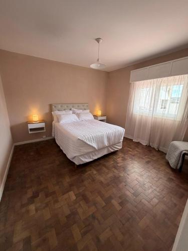 a bedroom with a bed and two lamps on two tables at Hospedajes Edén in La Falda