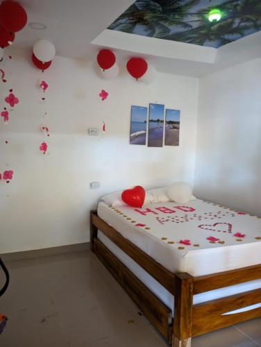 a bedroom with a bed with red balloons on the wall at Hotel Y Restaurante Verano Azul in Moñitos