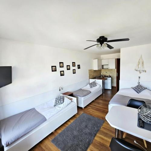 a living room with two beds and a ceiling fan at Fox pokoje-apartament-domki in Władysławowo