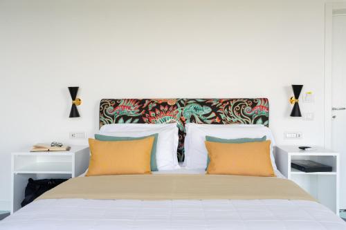a bedroom with a white bed with two orange pillows at Vanity Suite in Sorrento