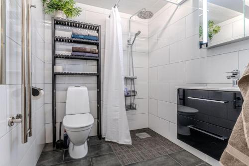 a white bathroom with a toilet and a sink at Newly built souterrain apartment in Älvsbacka in Skellefteå