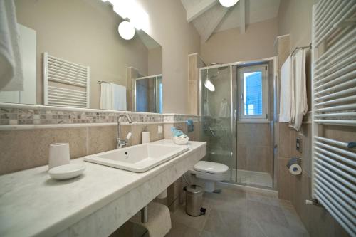 a bathroom with a sink and a toilet and a shower at Andromeda Villa in Tranakatika
