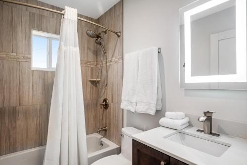a bathroom with a white shower curtain and a sink at BP04FLR Sunset Villa in Big Pine Key