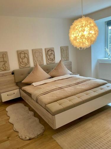 a bedroom with a large bed and a chandelier at Apartment Hornberg-Melisa in Hornberg