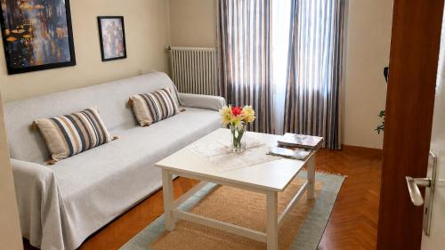a living room with a couch and a table with flowers on it at Alexandra's house in Arta