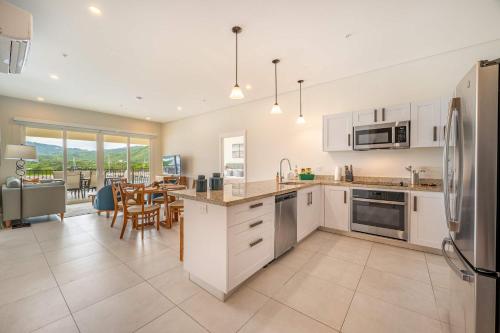 a kitchen with white cabinets and a dining room at Luxury Marina Suite 2BR in Playa Flamingo