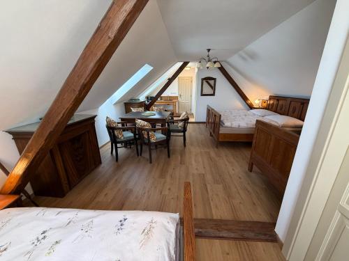 a attic room with a bedroom and a dining table at Chalupa na Brdech in Obecnice