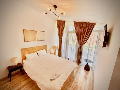 a bedroom with a bed with white sheets and a window at Salt Cabins in Ocniţa
