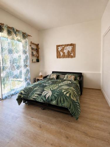 a bedroom with a bed with a green blanket at Studio la garrigue in Les-Pennes-Mirabeau