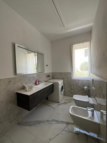 a bathroom with a sink and a toilet and a mirror at Appartamenti Gemma in Calmasino
