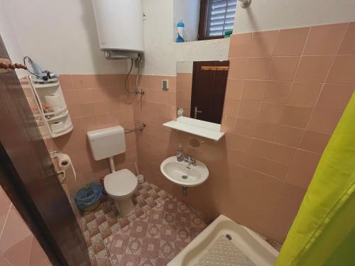 a small bathroom with a toilet and a sink at APARTMAN RUŽICA in Cres