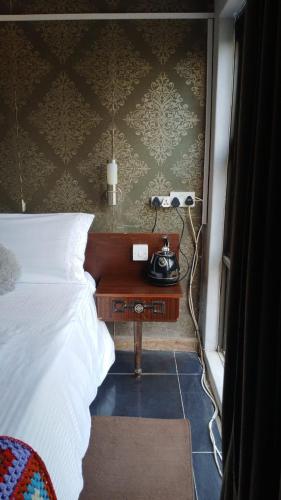 a bedroom with a bed and a telephone on a table at Urban Villa 25 in Gaborone