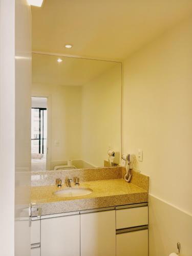 a bathroom with a sink and a large mirror at Casa Villa Constanza in Itaipava