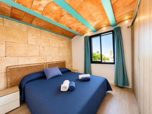 a bedroom with a blue bed with towels on it at La Esquineta de Tabarca in Tabarca