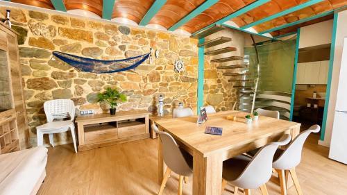 a room with a table and chairs and a stone wall at La Esquineta de Tabarca in Tabarca