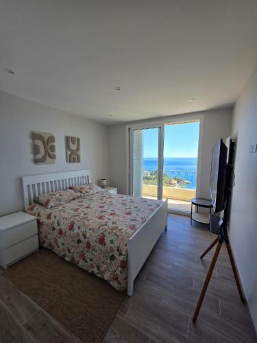 a bedroom with a bed and a flat screen tv at Duplex Residence with Monte Carlo Sea View & 2 Terraces in Roquebrune-Cap-Martin
