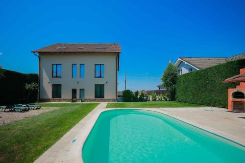 a house and a swimming pool in front of a house at Sunrise Villa in Baile Felix