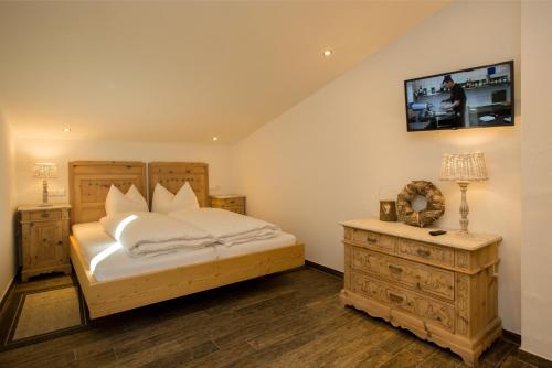 a bedroom with a bed and a wooden dresser at Apart Lutz in Prutz