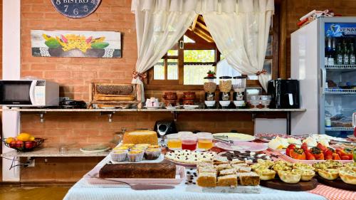 a table with cakes and other desserts on it at Pousada Villa do Luar by Concavus in Monte Verde